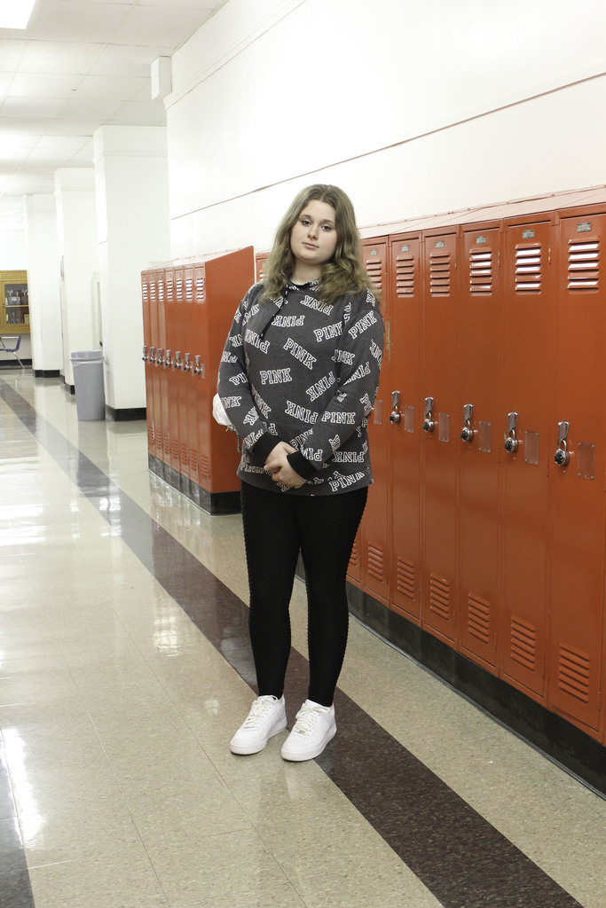 girl standing in hallway in front of lockers