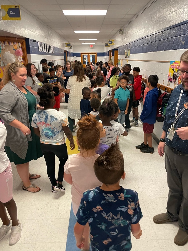 students and staff in the hallway dancing and giving high fives!