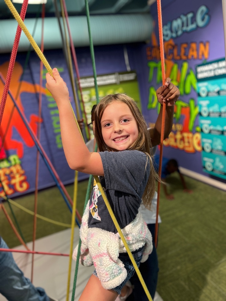 student in playing in the ropes course